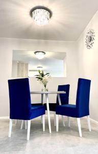 a dining room with a table and blue chairs at Apartament z basenem Baltic Garden Sztutowo, Mierzeja Wiślana in Sztutowo