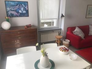 ein Wohnzimmer mit einem weißen Tisch und einem roten Stuhl in der Unterkunft Da Giuditta FreeCarPark&Garden in Domodossola