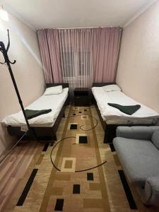 a small room with two beds and a couch at Jasmin in Karakol