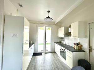 cocina con armarios blancos y ventana grande en Caporizon-Villa Jan Lou-CLIM-TERRASSE, en Labenne
