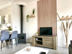 sala de estar con TV, mesa y sillas en Caporizon-Villa Jan Lou-CLIM-TERRASSE, en Labenne