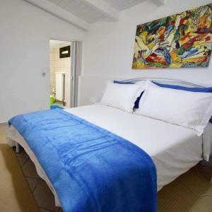 ein Schlafzimmer mit einem weißen Bett und einem Gemälde an der Wand in der Unterkunft Sideroporta castle Náfpaktos in Nafpaktos