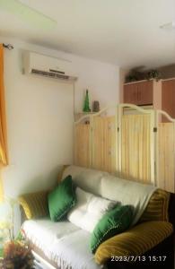 ein Sofa im Wohnzimmer mit grünen und weißen Kissen in der Unterkunft Ático Roquetas in Roquetas de Mar