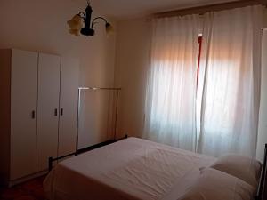 a bedroom with a white bed and a window at Home Life in Venturina Terme