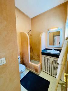 a bathroom with a sink and a toilet and a mirror at Riad Nour Beldi - Nice house near Medina in Marrakesh