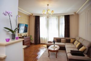 a living room with a couch and a table at Várkert Deluxe Apartmanház in Miskolc