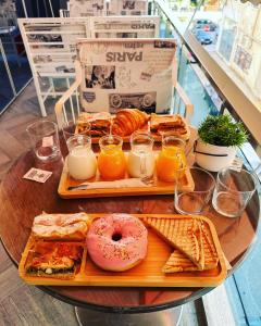 uma mesa com duas bandejas de comida e um donut e pão em Hotel Vasho em Gjirokastër