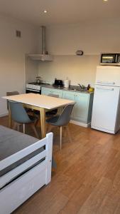 Una cocina con una mesa y un refrigerador blanco. en 25puntocinco deptos Tandil, en Tandil