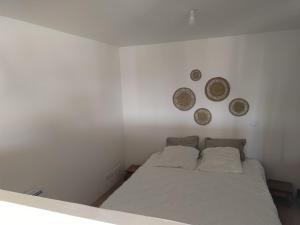 a bedroom with a bed and three plates on the wall at Studio secteur pic Saint Loup in Combaillaux