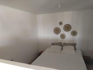 sypialnia z łóżkiem i 3 płytami na ścianie w obiekcie Studio secteur pic Saint Loup w mieście Combaillaux