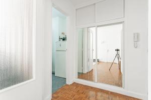 um quarto branco com uma porta de vidro e um tripé em La Suite d'Avenue Foche em Paris
