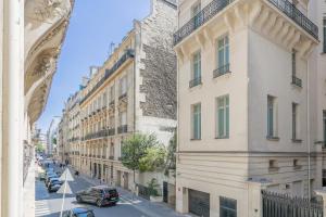 uma rua numa cidade com edifícios e um carro em La Suite d'Avenue Foche em Paris
