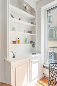 um quarto com prateleiras brancas e uma janela em La Suite d'Avenue Foche em Paris