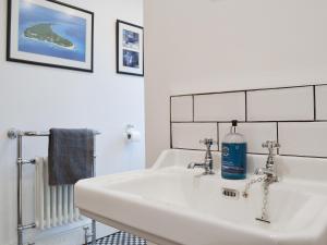 a bathroom with a sink with a bottle of soap at The Manse in Coxhoe