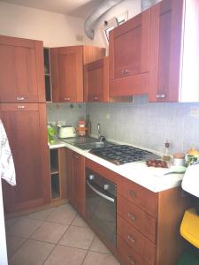 uma cozinha com armários de madeira e um forno com placa de fogão em Marechiaro em Rimini