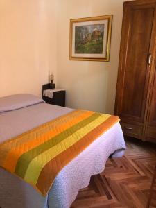 1 dormitorio con 1 cama con una manta colorida en Borgo Villa, en Acceglio