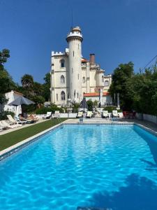 uma piscina em frente a um edifício com um castelo em Vila Aurora no Luso