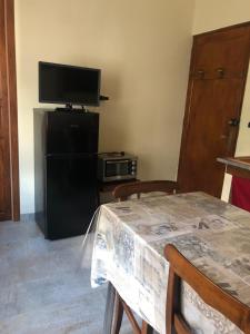 sala de estar con mesa y TV en Borgo Villa, en Acceglio