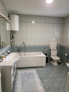 a bathroom with a tub and a toilet and a sink at ROYAL Apartmani in Bosanski Šamac