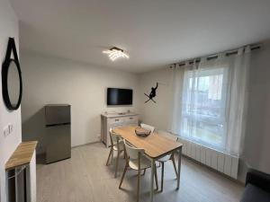 a living room with a table and chairs and a television at 4 pers, pied des pistes, WIFI, Netflix, Lave-vaisselle in Les Deux Alpes