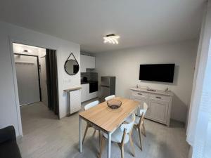 a dining room with a table and chairs and a television at 4 pers, pied des pistes, WIFI, Netflix, Lave-vaisselle in Les Deux Alpes