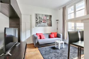 a living room with a couch and a tv at Appartement Quartier Parc Georges Brassens in Paris