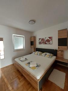 een slaapkamer met een groot bed in een kamer bij Apartmani Cindrić in Stara Baška