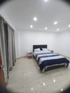 um quarto com uma cama com um edredão azul em Casa de Campo Las Tujas em Lunahuaná