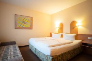 a hotel room with a large white bed in it at Hotel Zum Prinzen Sinsheim in Sinsheim +77 photos