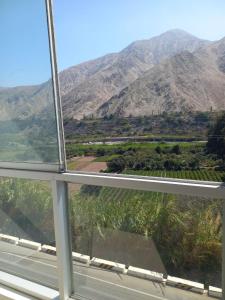uma vista para uma montanha a partir de uma janela em Casa de Campo Las Tujas em Lunahuaná