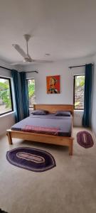 a bedroom with a bed and two windows at Maracuja villa Zanzibar in Bwejuu