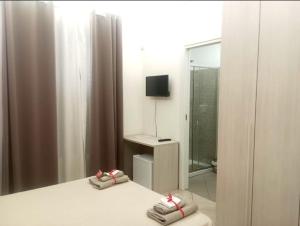 ザッフェラーナ・エトネーアにあるVilla longardiのベッドルーム1室(ベッド1台、テレビ、タオル付)