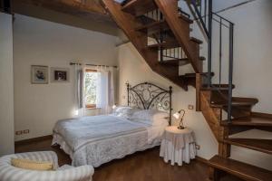 a bedroom with a large bed and a staircase at Casale con vista sui Monti Sibillini e piscina in Amandola