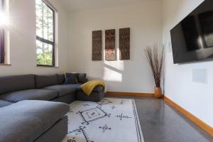 uma sala de estar com um sofá e uma televisão em Tree Fern Guest House em Tofino