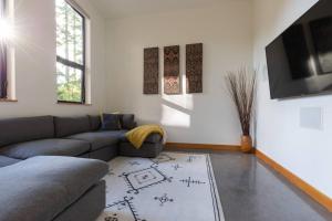 a living room with a couch and a tv at Tree Fern Guest House in Tofino