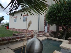 a fountain in front of a house with a ball in the water at Miss Tine 