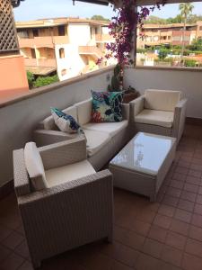 balkon z kanapami, krzesłami i stołem w obiekcie Blu Village 2 (MT) w mieście Marina di Pisticci