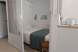 Habitación pequeña con cama y ventana en Mira Marvel - WIFI - Climatisation - 100m plage en Biarritz