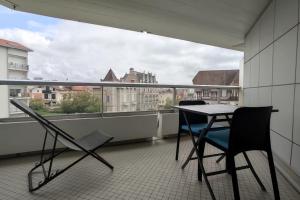 una mesa y sillas en un balcón con vistas en Mira Marvel - WIFI - Climatisation - 100m plage en Biarritz