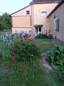 Le refuge في Ceton: حديقة بها زهور وردية وأرجوانية أمام المبنى