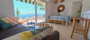 a living room with a couch and a large window at Vue mer à couper le souffle - nouveau entièrement rénové in Cannes
