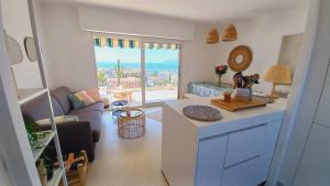 a kitchen and living room with a view of the ocean at Vue mer à couper le souffle - nouveau entièrement rénové in Cannes +54 photos