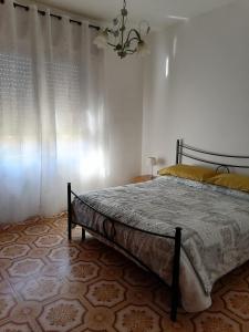 um quarto com uma cama e um lustre em The Garden em Tortolì