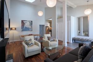ein Wohnzimmer mit 2 Stühlen und einem Tisch in der Unterkunft Boardwalk Homes Executive Suites in Kitchener