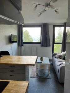 a living room with a table and a couch at studio 4 pers praloup 1600 in Uvernet
