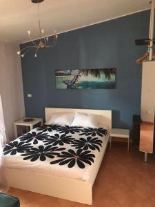 sypialnia z łóżkiem i niebieską ścianą w obiekcie Blu Village 2 (MT) w mieście Marina di Pisticci