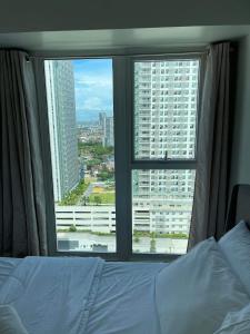 a bedroom with a bed and a large window at 2BR spacious stylish condo near mall in Cebu City
