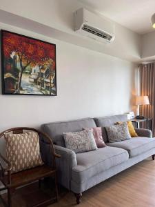 a living room with a couch and a painting on the wall at 2BR spacious stylish condo near mall in Cebu City