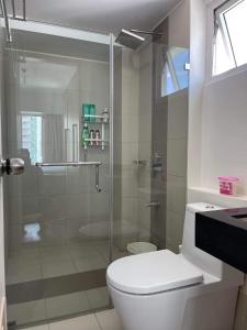 uma casa de banho com um WC e uma cabina de duche em vidro. em 2BR spacious stylish condo near mall em Cebu