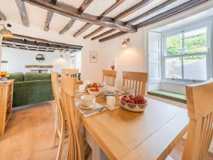 a dining room and living room with a wooden table at Rose Garden Cottage in Heversham